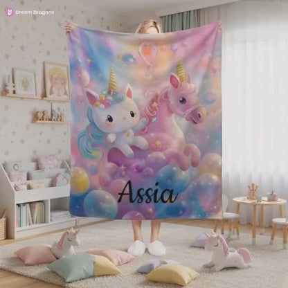 Smiling woman holding the purple, pink name blanket with a unicorn and a Hello Kitty and the name Assia on it.